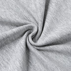 A close-up of light heather gray fabric arranged in a spiral drape to show texture and flexibility.