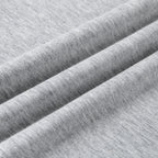Close-up of light heather gray fabric with soft diagonal folds showing the knit texture.